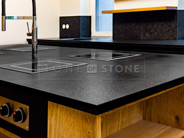 Detail varného ostrůvku ze žuly Nero Assoluto Zimbabwe (trattato), v pozadí kuchyňská deska a parapet ze stejného přírodního kamene. Zakázková výroba TONE OF STONE Detail varného ostrůvku ze žuly Nero Assoluto Zimbabwe (trattato), v pozadí kuchyňská deska a parapet ze stejného přírodního kamene. Zakázková výroba TONE OF STONE