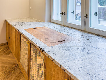 Kuchyňská pracovní deska z indické žuly Colonial White v úpravě satén. Do kuchyňské desky je vsazen dřez se spodní montáží a zabudovaný projektor. Integrovaný parapet s průduchy pro proudění teplého vzduchu z topení je součástí pracovní desky. Zakázková výroba TONE OF STONE. Kuchyňská pracovní deska z indické žuly Colonial White v úpravě satén. Do kuchyňské desky je vsazen dřez se spodní montáží a zabudovaný projektor. Integrovaný parapet s průduchy pro proudění teplého vzduchu z topení je součástí pracovní desky. Zakázková výroba TONE OF STONE.