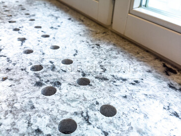 Detail průduchů pro proudění teplého vzduchu, které jsou součástí pracovní desky a integrovaného parapetu ze žuly Colonial White. Zakázková výroba TONE OF STONE. Detail průduchů pro proudění teplého vzduchu, které jsou součástí pracovní desky a integrovaného parapetu ze žuly Colonial White. Zakázková výroba TONE OF STONE.