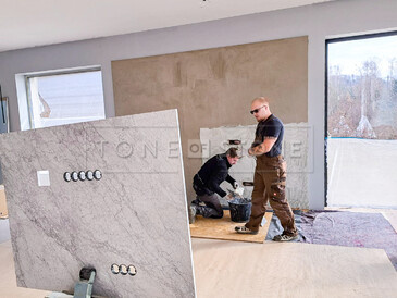Práce při obložení stěny přírodním mramorem Bianco Carrara Práce při obložení stěny přírodním mramorem Bianco Carrara