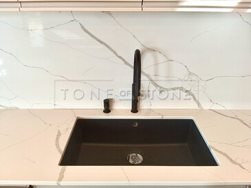 Kamenná pracovní deska z Technistone Crystal Calacatta Silva - černý kuchyňský dřez se spodní montáží a kamenný obklad Kamenná pracovní deska z Technistone Crystal Calacatta Silva - černý kuchyňský dřez se spodní montáží a kamenný obklad