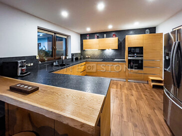 Kuchyňská deska z kartáčované žuly Steel grey doplněná o obklad stěny a kamenný parapet. Zakázková výroba TONE OF STONE. Kuchyňská deska z kartáčované žuly Steel grey doplněná o obklad stěny a kamenný parapet. Zakázková výroba TONE OF STONE.