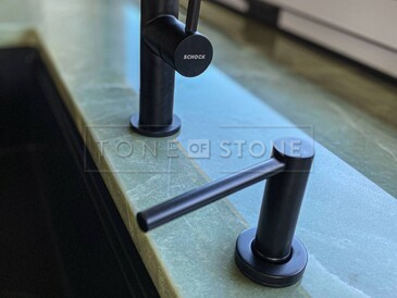 Detail instalace baterie a dávkovače saponátu do kamenné desky ze zeleného přírodního kamene Jadore Detail instalace baterie a dávkovače saponátu do kamenné desky ze zeleného přírodního kamene Jadore