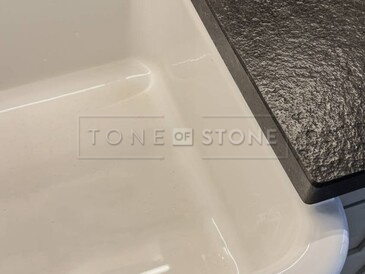 Žulová kuchyňská deska z přírodního kamene Nero Assoluto Zimbabwe s přesahem okolo keramického dřezu Žulová kuchyňská deska z přírodního kamene Nero Assoluto Zimbabwe s přesahem okolo keramického dřezu