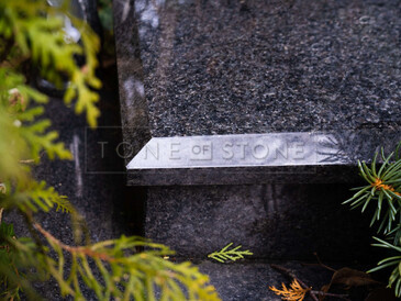 Detail hrany desky urnového pomníku z přírodního kamene - žula Impala, zakázková výroba TONE OF STONE. Detail hrany desky urnového pomníku z přírodního kamene - žula Impala, zakázková výroba TONE OF STONE.