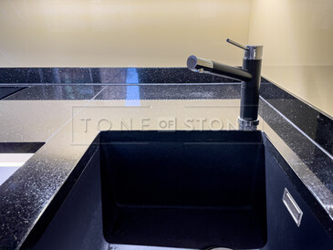 Kuchyňská pracovní deska z přírodního kamene - leštěná černá žula s třpytivými fragmenty - STAR GALAXY, detail přisazeného spodního dřezu a baterie Kuchyňská pracovní deska z přírodního kamene - leštěná černá žula s třpytivými fragmenty - STAR GALAXY, detail přisazeného spodního dřezu a baterie